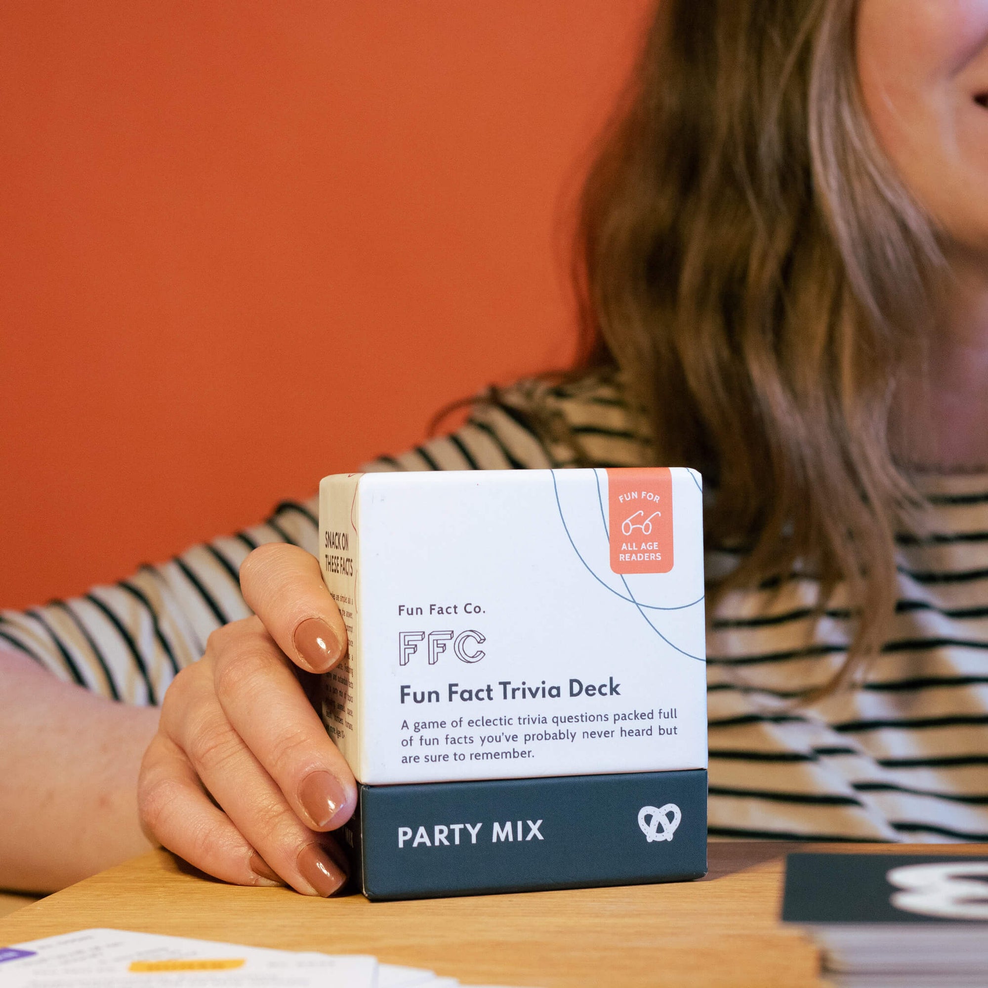 girl holding the trivia deck box