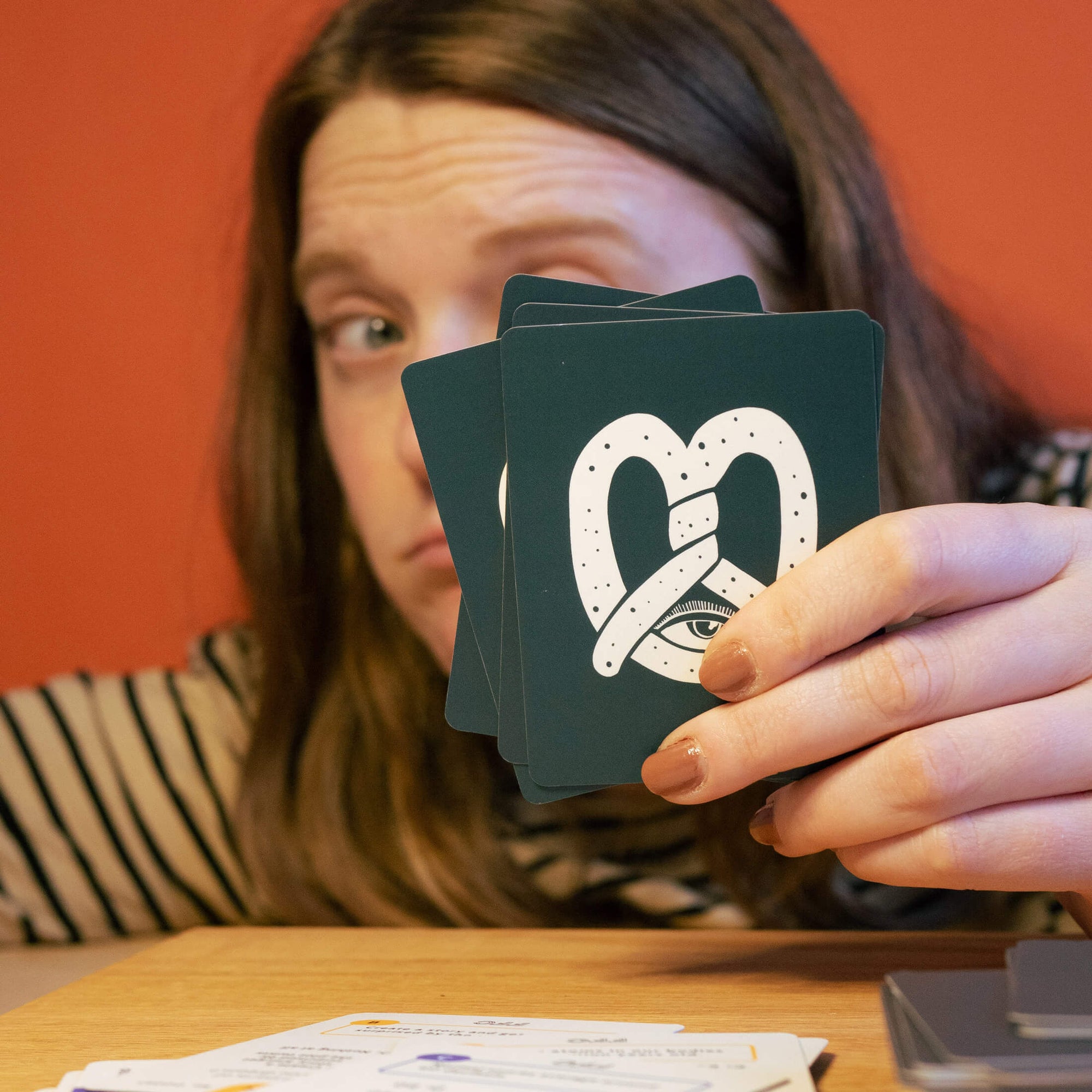 girl holding up a card from the trivia deck and looking suspicious