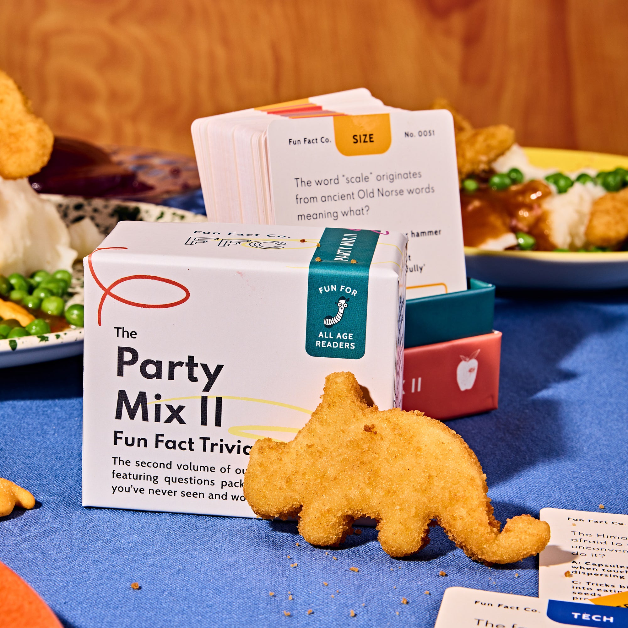 Party Mix II Fun Fact Trivia box with a toy elephant on a table with food in the background
