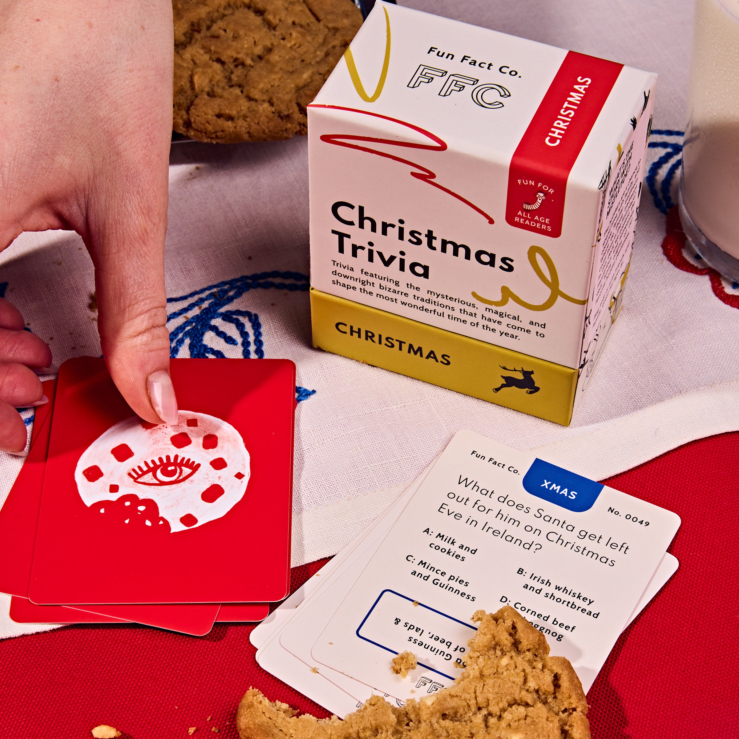 Christmas trivia game with cards and a box labeled 'Fun Fast Co. Christmas Trivia' on a festive table.